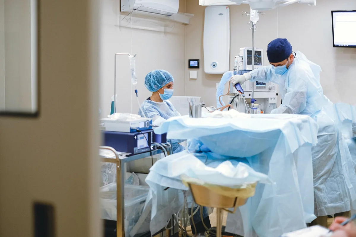Equipe cirúrgica em sala de cirurgia durante procedimento por vídeo
